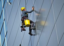 persona trabajando en alturas limpiando vidrios de un edificio