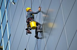 persona trabajando en alturas limpiando vidrios de un edificio